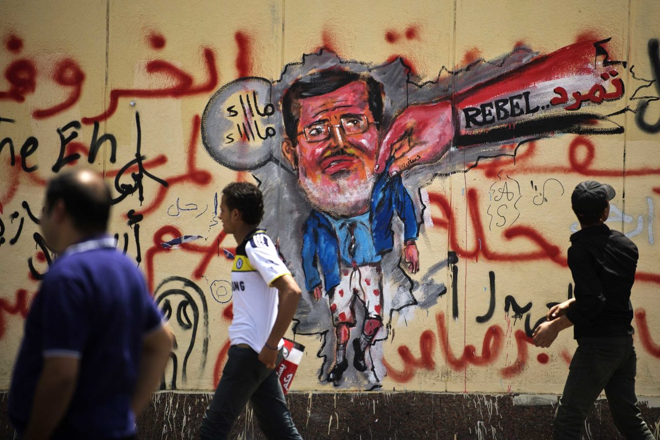 egyptians walk past anti morsi graffiti data