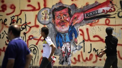 egyptians walk past anti morsi graffiti data