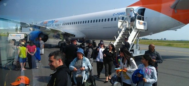 passengers file out of sunwing flight 772