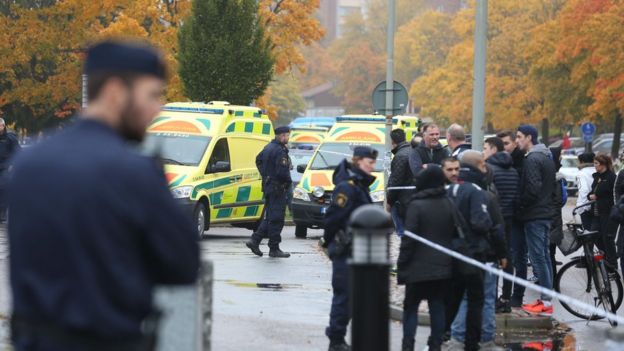 Swedish police officers survey a secured area outside a primary and middle school in Trollhattan, southwestern Sweden, on October 22, 2015,