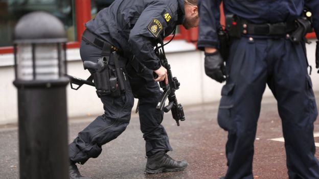 Police officers secure the area after a masked man attacked people with a sword, at the Kronan school in Trollhattan, Sweden, Thursday Oct. 22, 2015