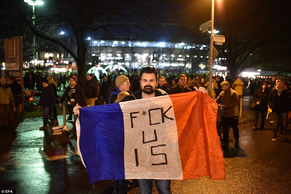 A supporter holds a French flag outside the HDI-Arena stadium shortly before it was announced the game was called off 