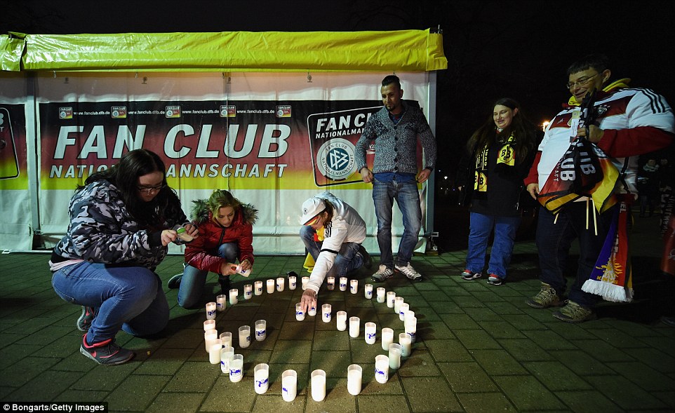 Fans lights candles in remembrance of the 129 killed in the Paris terrorism attacks on Friday prior to tonight's game 