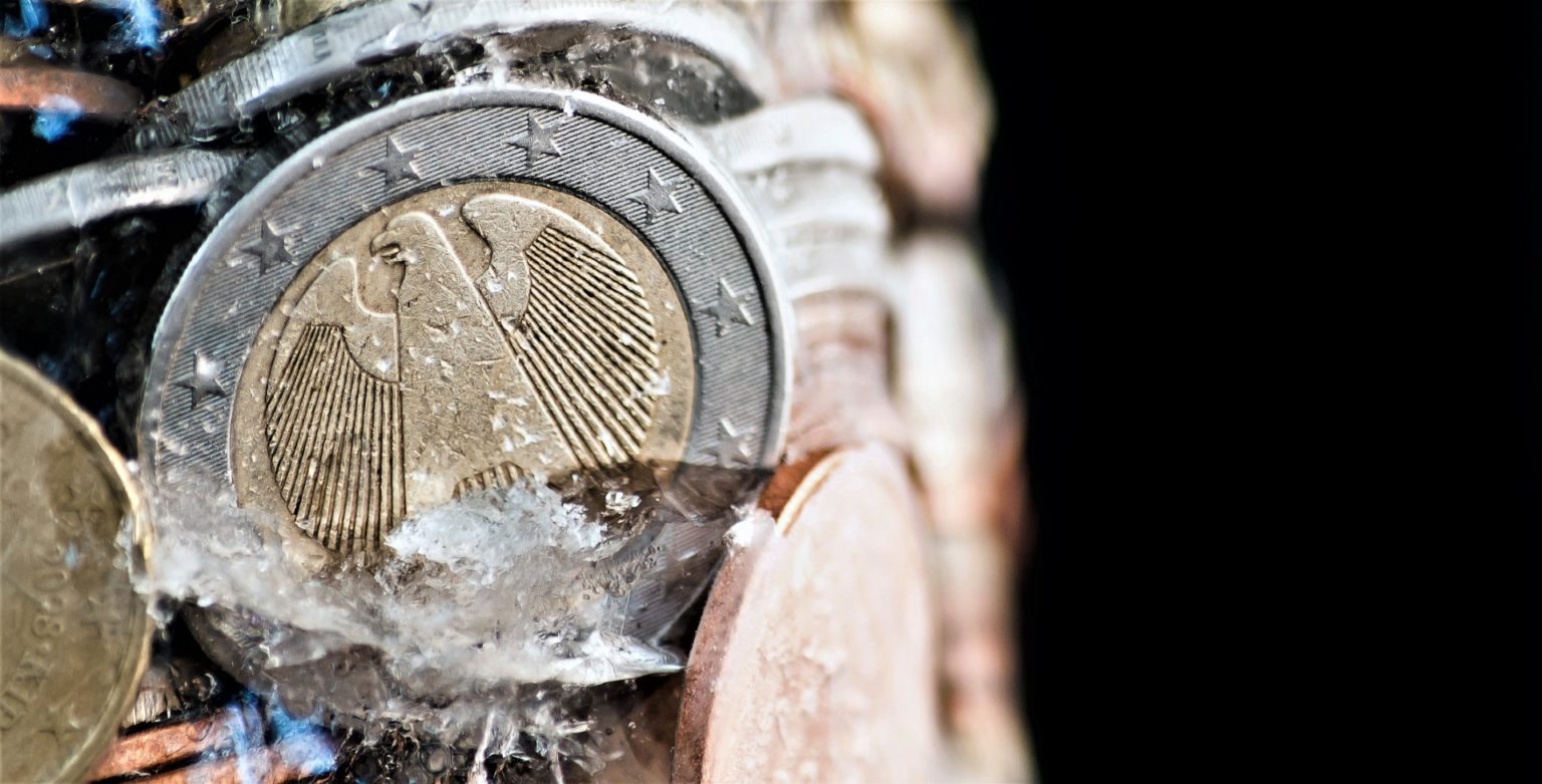 shiny euro coins frozen in ice with german coin in front MJ4F sR