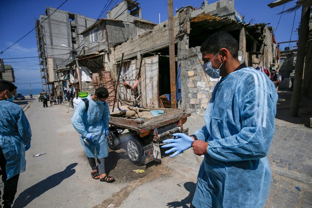 palestinian volunteers spray disinfectant in al shati refugee camp in gaza city during a campaign to curb the coronavirus outbreak. afp